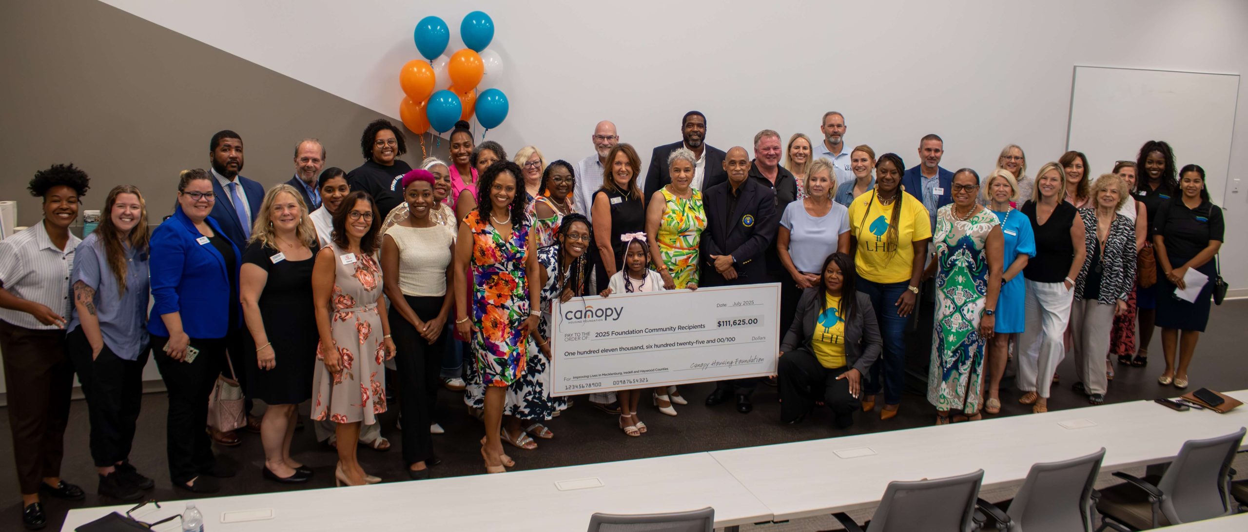 Attendees of the 2025 Mecklenburg and Iredell Counties Grants Award Celebration hold a "big check" in the amount of $111,625.