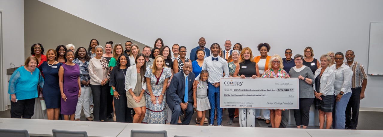 2026 Community Grants, nonprofit representatives hold up the "big check", showing a total of $85,500 distributed within Mecklenburg and Iredell Counties in North Carolina